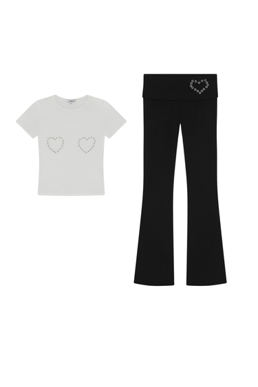 White t-shirt and black pants with heart designs on a white background